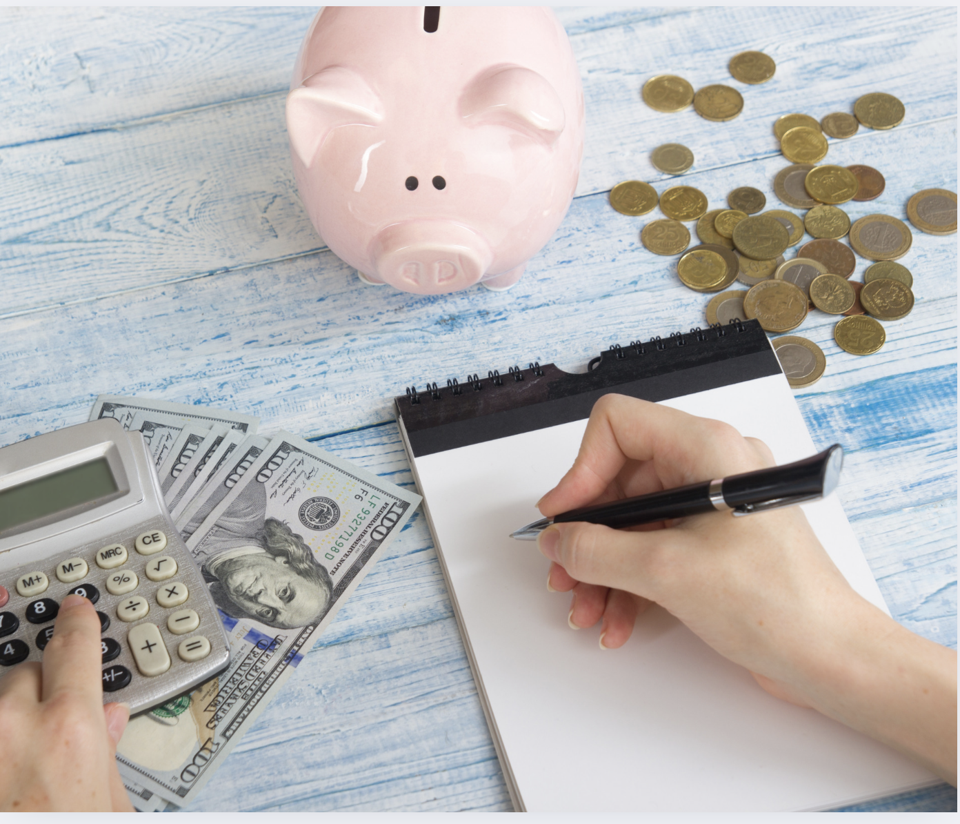 piggy bank, money and calculator on wooden table